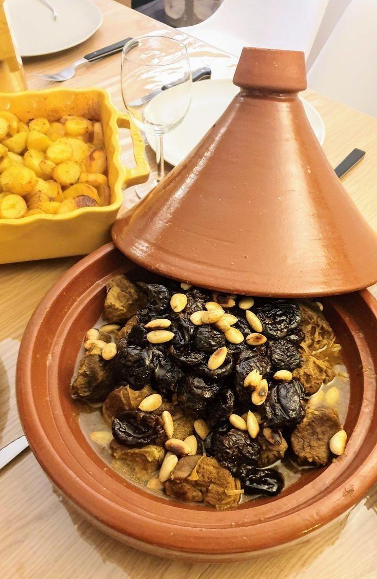 A Moroccan tagine surrounded by salads and bread on a low table
