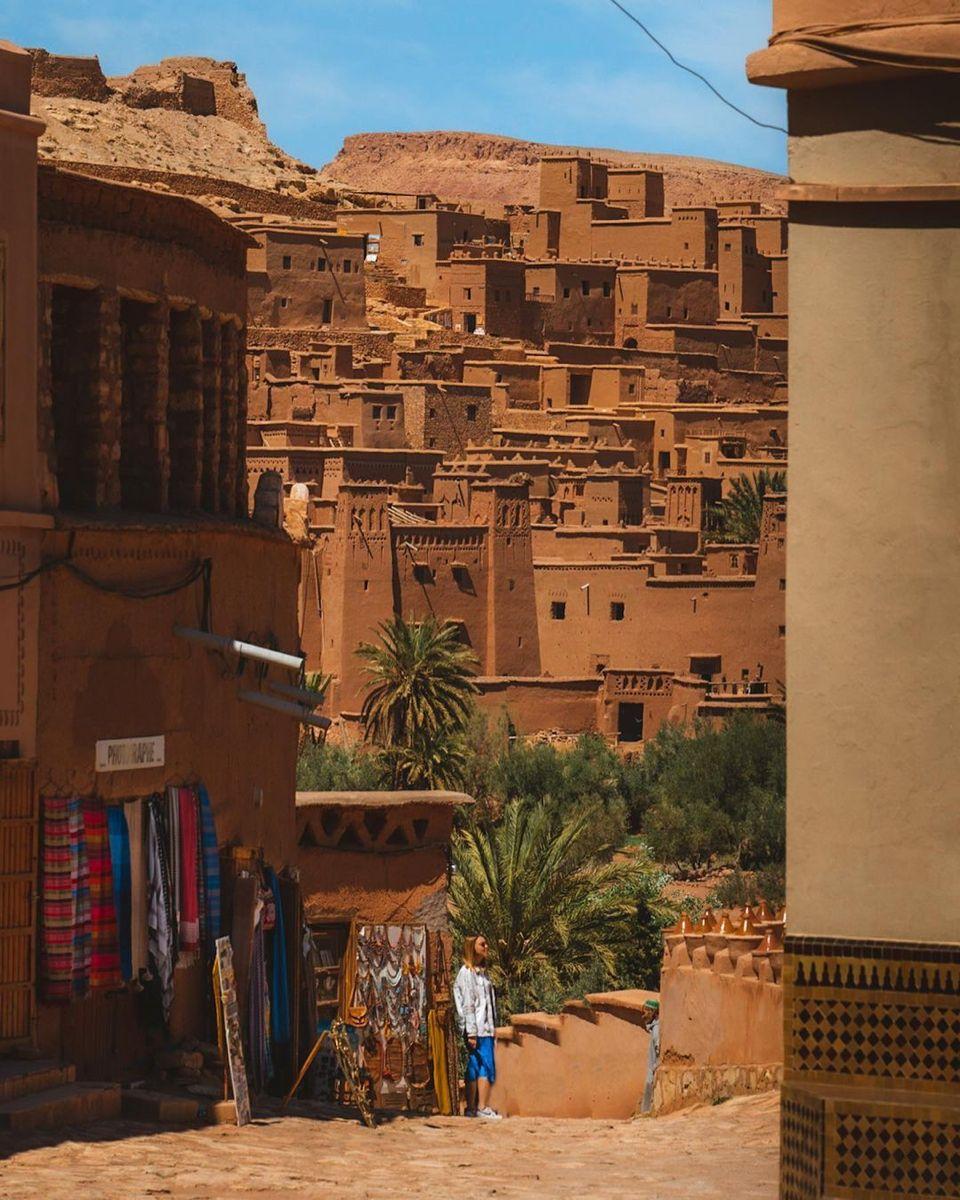 A Moroccan medina street with lanterns and craft workshops