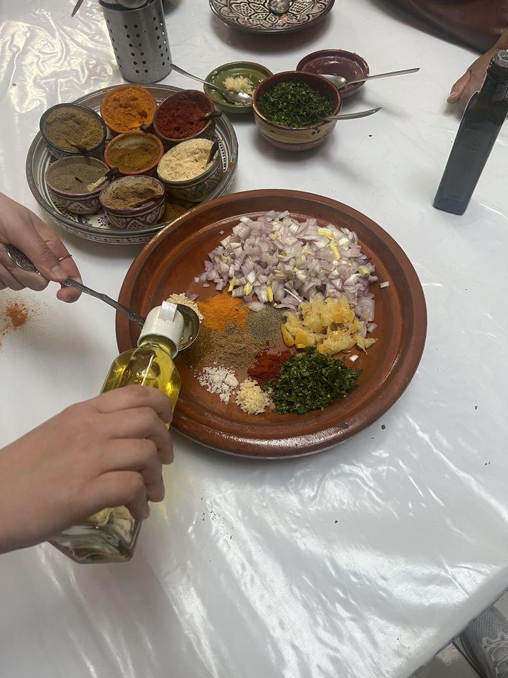 Hands preparing vegetables and spices for a tagine in a Moroccan kitchen